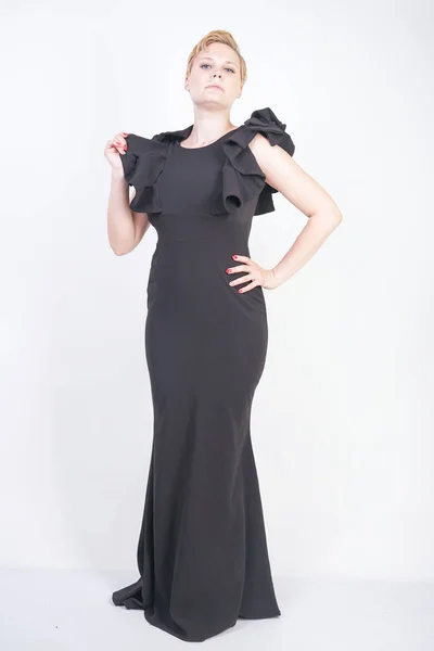 Portrett av en attraktiv, lubben ung kvinne i trang svart kjole – stockfoto