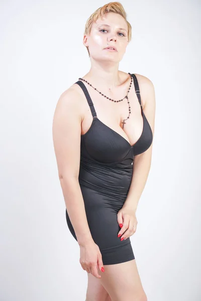 Portrait de jolie jeune femme joufflue en robe noire serrée — Photo