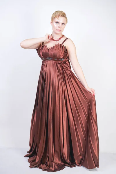 Joven embarazada en un vestido de noche largo plisado marrón — Foto de Stock
