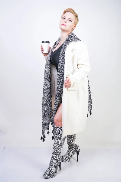 Plus μέγεθος γυναίκα σε λευκό μαλλί παλτό με ζέβρα κασκόλ κρατά καφέ — Φωτογραφία Αρχείου
