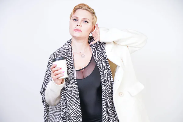 Plus size woman in white wool coat with zebra scarf holds coffee — Stock Photo, Image