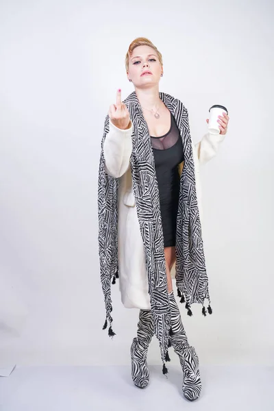 Плюс размер женщина в белой шерсти пальто с зеброй шарф держит кофе — стоковое фото