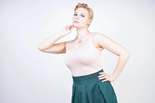 Pin up curvy girl in green pleated midi skirt on white — Stock Photo, Image