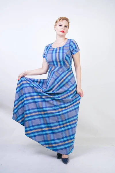 Cute plus size blonde girl in a long rustic plaid blue dress — Stock Photo, Image