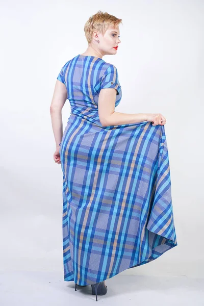 Cute plus size blonde girl in a long rustic plaid blue dress — Stock Photo, Image