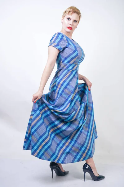 Χαριτωμένο συν μέγεθος ξανθιά κορίτσι σε ένα μακρύ ρουστίκ καρό μπλε φόρεμα — Φωτογραφία Αρχείου
