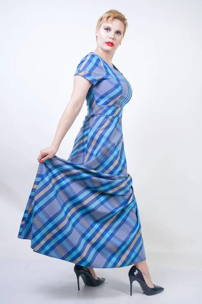 Cute plus size blonde girl in a long rustic plaid blue dress — Stock Photo, Image