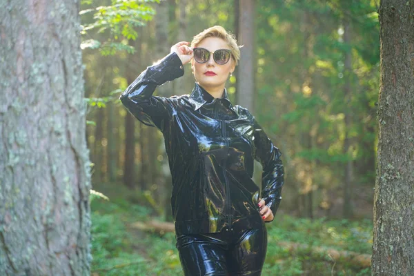 Mujer de moda de goma de látex caminando en el bosque —  Fotos de Stock