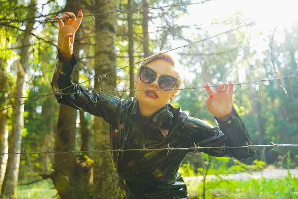 Mujer de moda de goma de látex caminando en el bosque —  Fotos de Stock