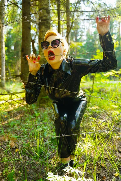 Mujer de moda de goma de látex caminando en el bosque — Foto de Stock