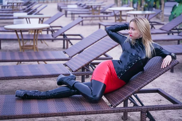 Femme chaude en caoutchouc noir vêtements de mode le soir sur la plage — Photo