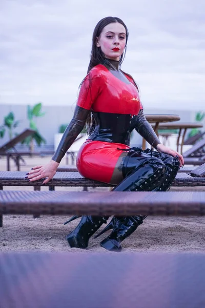 Mode stijlvolle dame slijtage latex rubber kleren op het strand buiten — Stockfoto