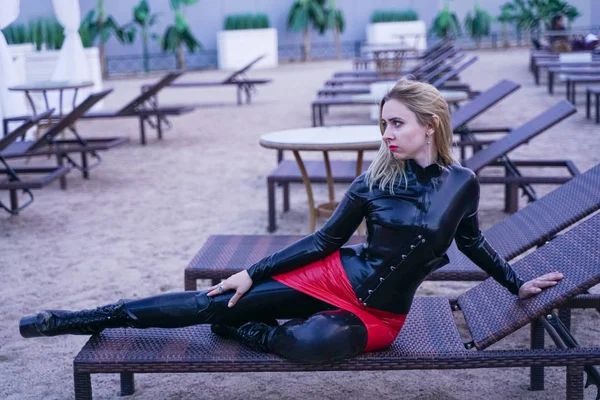 Femme chaude en caoutchouc noir vêtements de mode le soir sur la plage — Photo