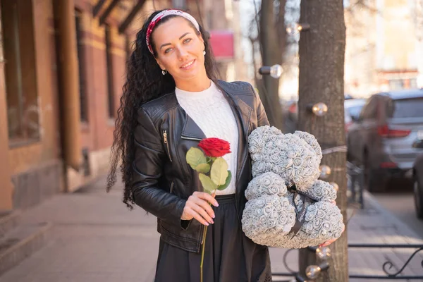 Vacker kvinna som går i staden med grå nallebjörn av foamirane Roses. — Stockfoto