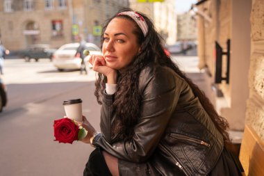 Sokakta kahve içen birini bekleyen kadın