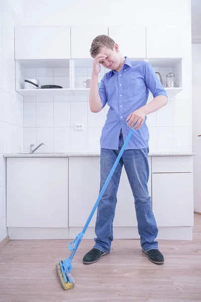 Adolescente Boy Mopping El Piso y ayuda a sus padres a limpiar en la cocina — Foto de Stock