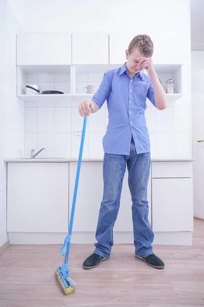 Adolescente Boy Mopping El Piso y ayuda a sus padres a limpiar en la cocina — Foto de Stock