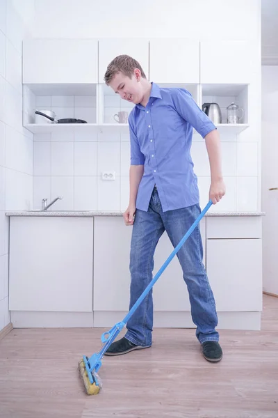 Adolescente Boy Mopping El Piso y ayuda a sus padres a limpiar en la cocina — Foto de Stock