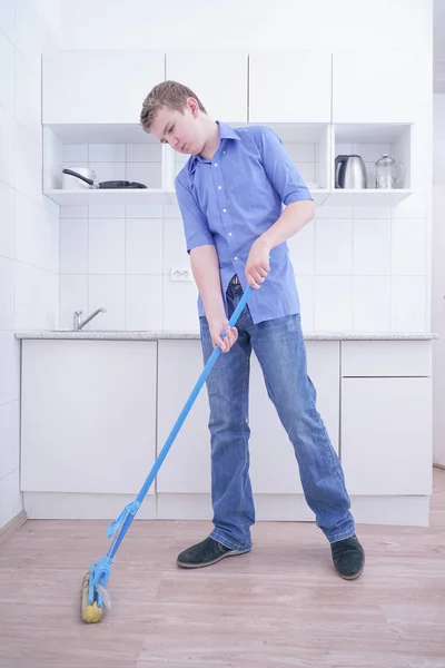 Teenager Boy Mopping The Floor and helps his parents to clean on kitchen — Stock Photo, Image