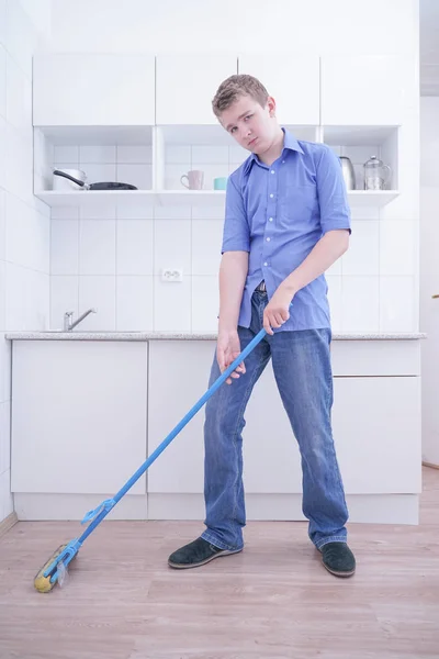Adolescente Boy Mopping El Piso y ayuda a sus padres a limpiar en la cocina — Foto de Stock