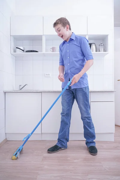 Adolescente Boy Mopping El Piso y ayuda a sus padres a limpiar en la cocina — Foto de Stock