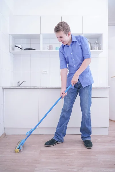 Adolescente Boy Mopping El Piso y ayuda a sus padres a limpiar en la cocina — Foto de Stock