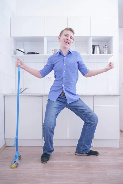 Chłopiec nastolatek Mopping piętro i pomaga rodzicom oczyścić w kuchni — Zdjęcie stockowe