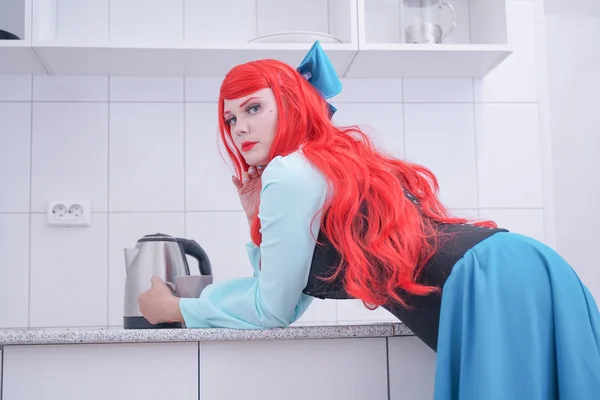 Joven chica de pelo rojo en vestido azul con corsé negro en la cocina —  Fotos de Stock