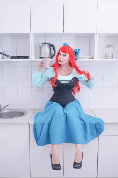 Młoda czerwona dziewczyna włosy w niebieskiej sukni z czarnym gorset na kuchni — Zdjęcie stockowe