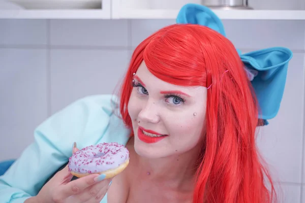 饥饿有吸引力的女孩吃甜甜圈在厨房 — 图库照片