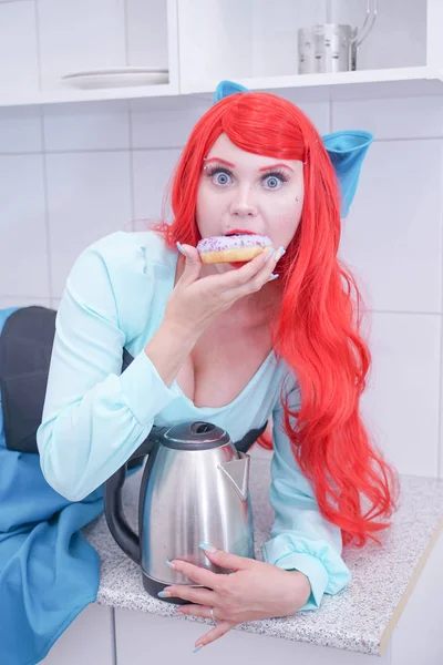Hungry attractive girl eating donut on the kitchen — Stock Photo, Image