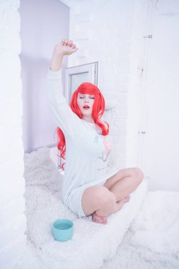 Uyandıktan sonra beyaz kürk pencere üzerinde uzanan kadın