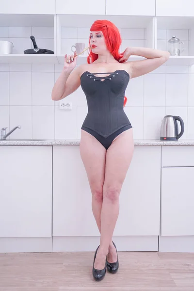 Lány fekete fűző vörös haj gazdaság Villa, fehér konyhában — Stock Fotó
