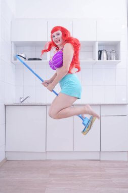 Artı boyutu kadın temizlik ev, paspas ile poz ve eğlenmek
