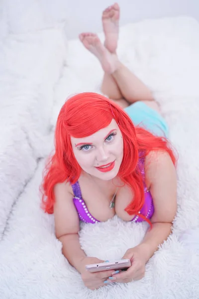 Elegante joven sexy mujer usando tableta y relajarse en la cama blanca —  Fotos de Stock
