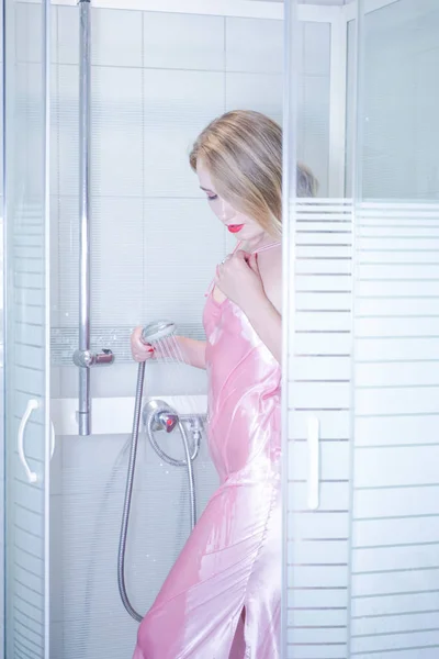 Mujer joven en lencería rosa lavándose solo en la ducha —  Fotos de Stock