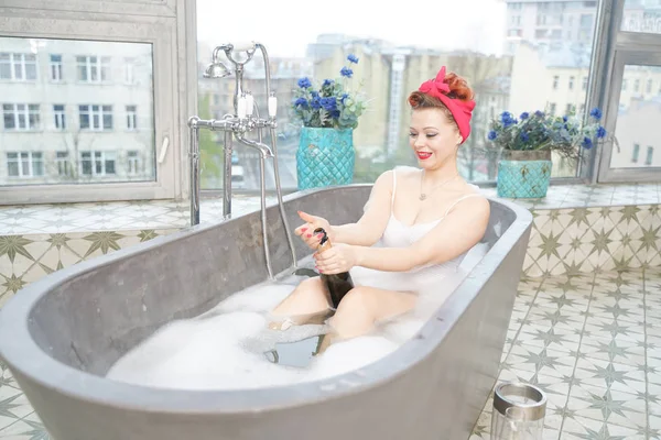 매혹적인 여자 복용 편안한 목욕 와 샴페인 에 그녀의 목욕 — 스톡 사진