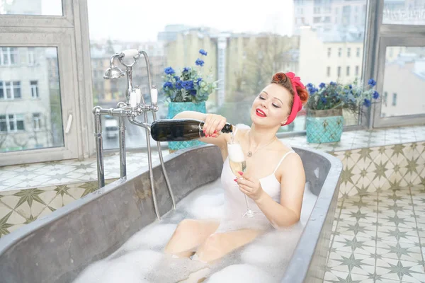 Donna seducente che fa un bagno rilassante con champagne nel suo bagno — Foto Stock