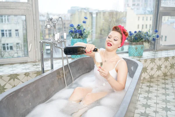 Förförisk kvinna tar avkopplande bad med champagne i hennes bad — Stockfoto