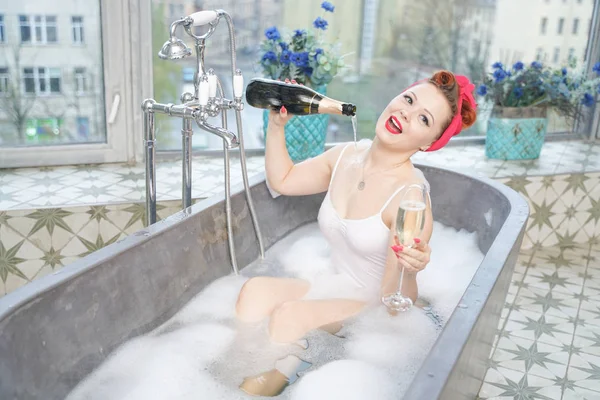 Verleidelijke vrouw die ontspannend bad met Champagne in haar bad neemt — Stockfoto