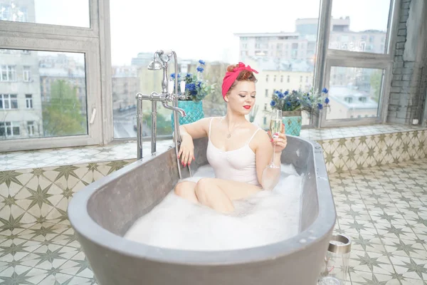Mujer seductora tomando baño relajante con champán en su baño — Foto de Stock
