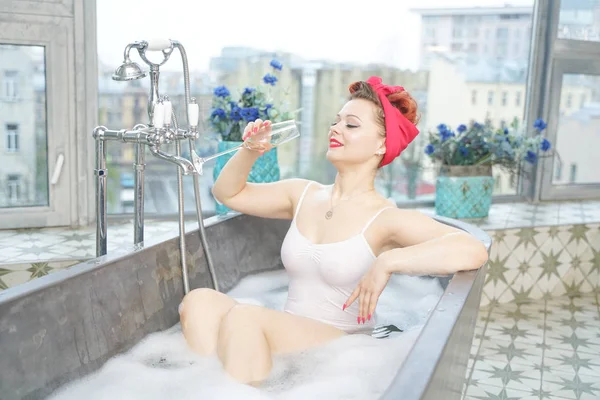Соблазнительная женщина принимает расслабляющую ванну с шампанским в ванной — стоковое фото