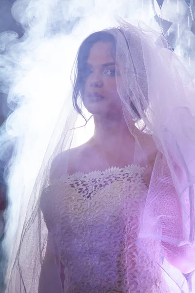 Portrait de la belle mariée contre une lumière à l'intérieur dans la fumée — Photo