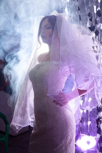 Portret pięknej panny młodej przed światłem w pomieszczeniu w dymie — Zdjęcie stockowe