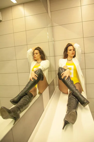 Красивая девушка в большом туалете рядом с зеркалом одна — стоковое фото