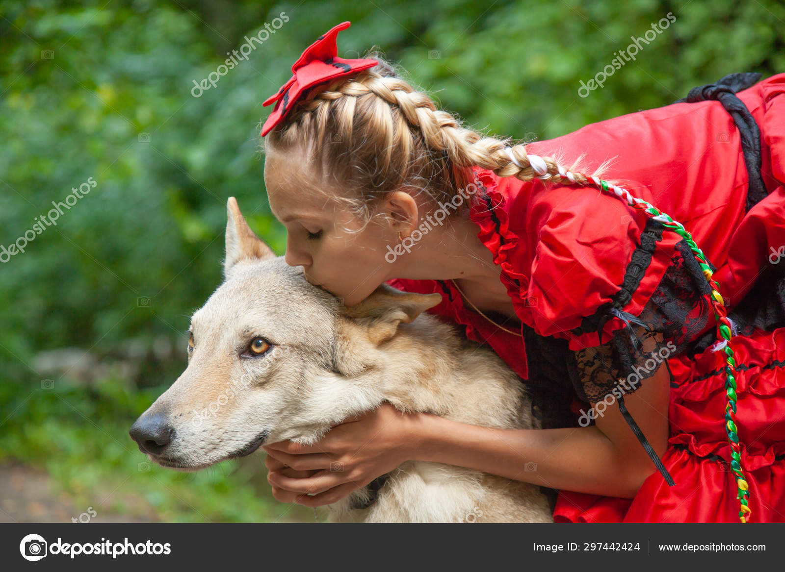 Cheerful pretty young woman in red dress sitting and hugging her
