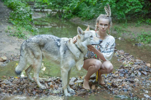 Menina étnica magro com seu cão lobo na floresta profunda sozinho — Fotografia de Stock