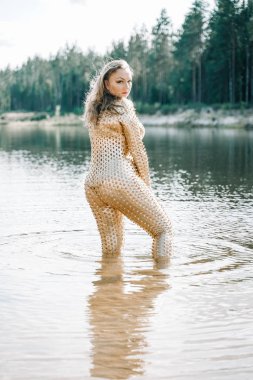 Altın fütüristik kıyafet içinde artı boyutu kıvrımlı vücut ile Kadın suda poz