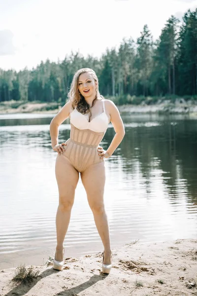 Plus Size vrouw met bochtige figuur in corset lingerie. Kaukasisch XXL mollig meisje wil zwemmen. — Stockfoto