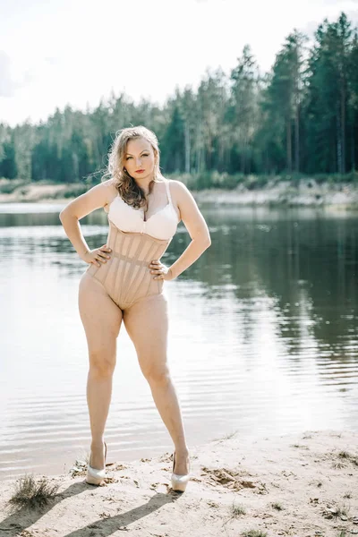 Plus Size vrouw met bochtige figuur in corset lingerie. Kaukasisch XXL mollig meisje wil zwemmen. — Stockfoto